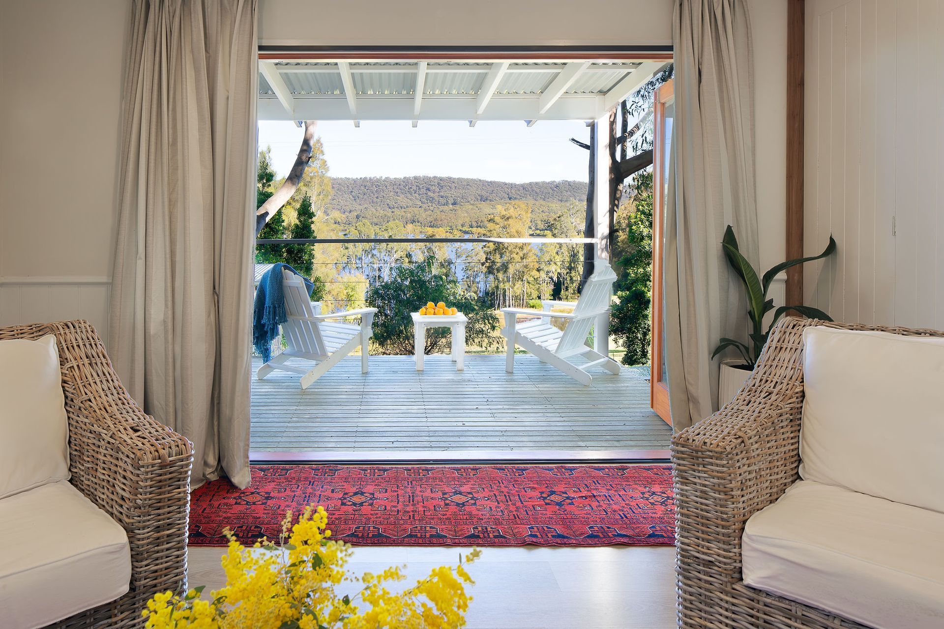 A living room with two chairs and a table with a view of a deck.