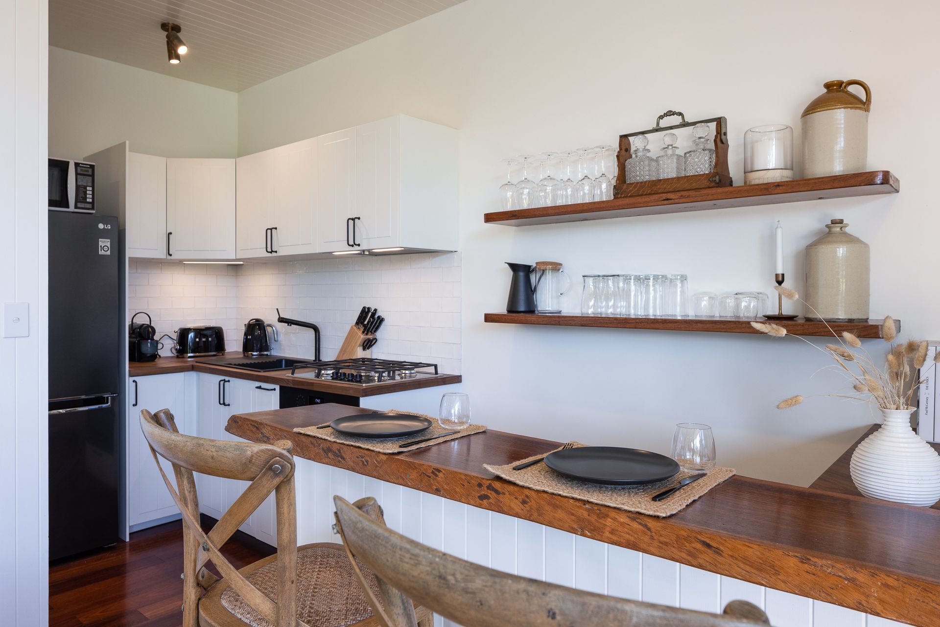 A kitchen with a table and chairs and a refrigerator.