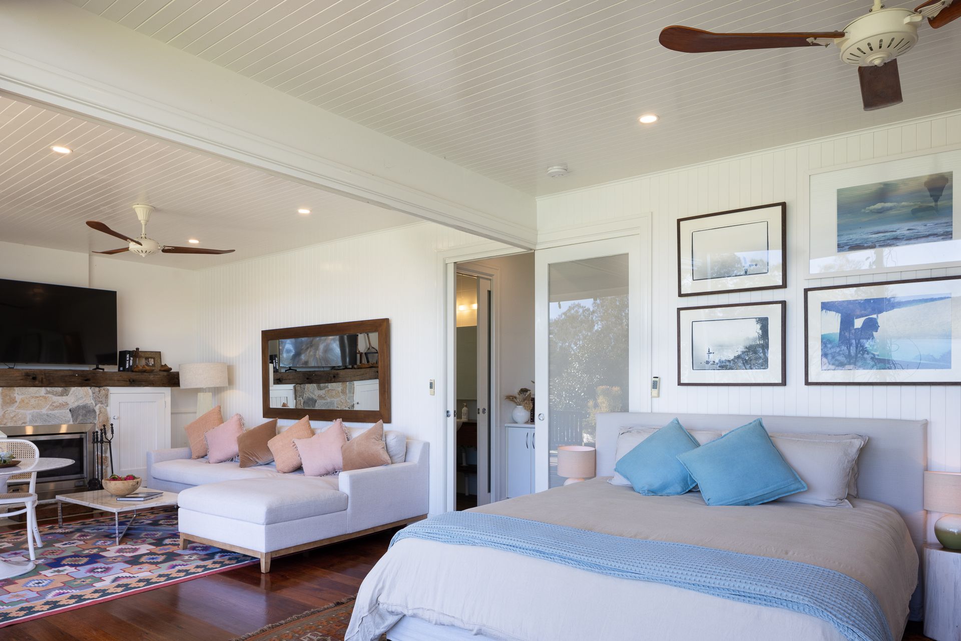 A bedroom with a large bed and a ceiling fan