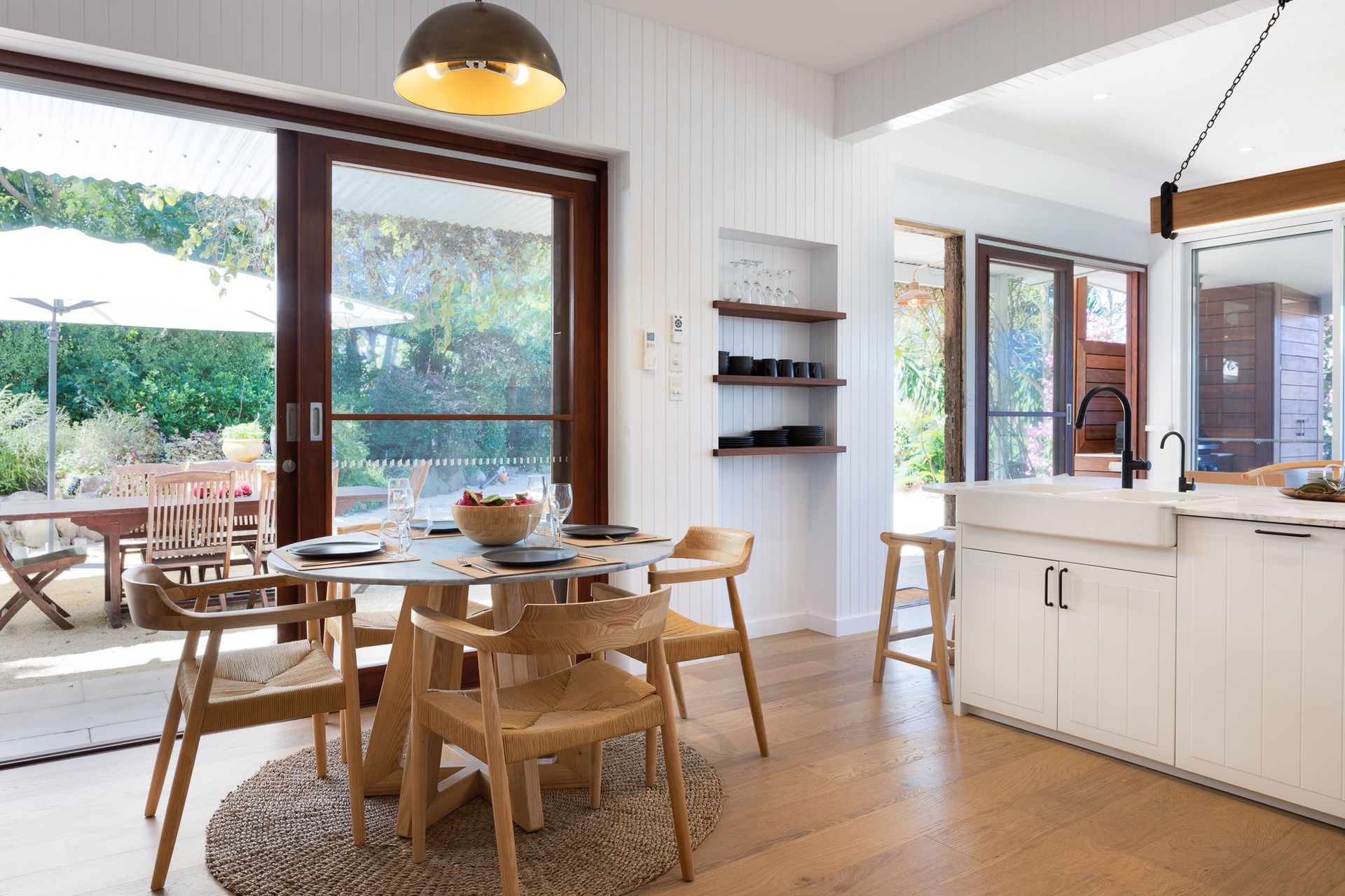 A kitchen with a table and chairs and a sliding glass door.