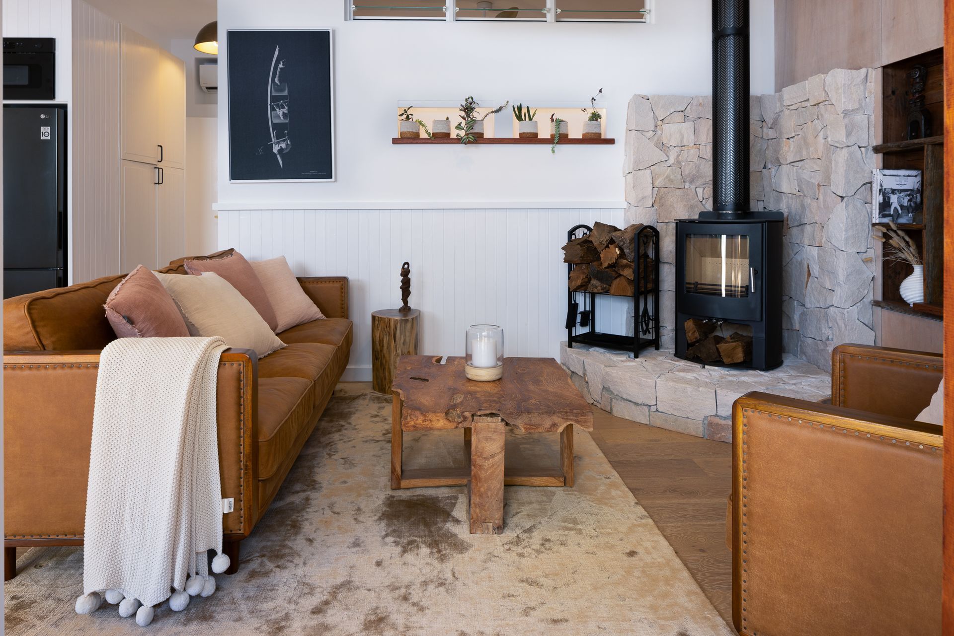 A living room with a couch , chairs , coffee table and fireplace.