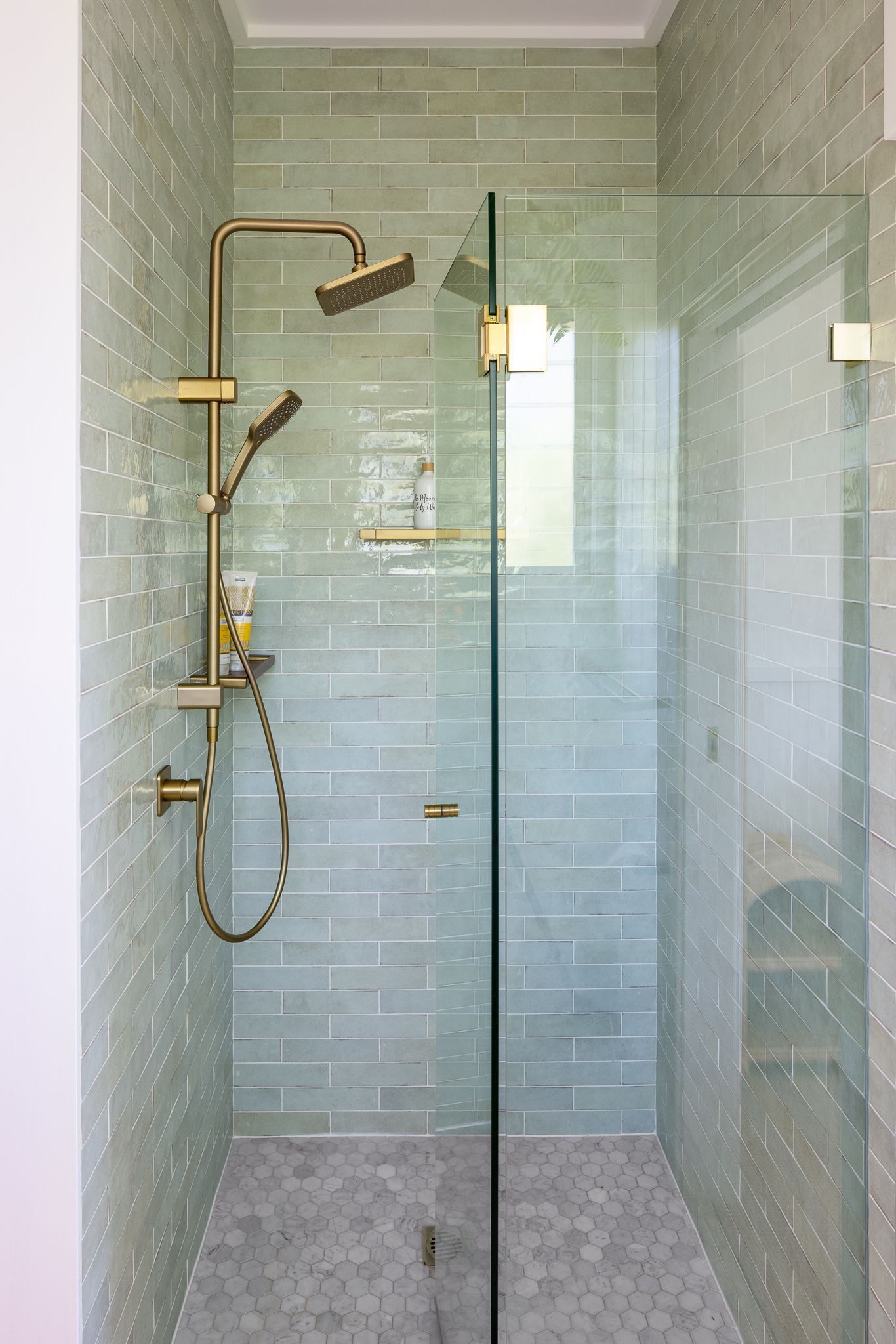 A shower stall with a glass door and a shower head.