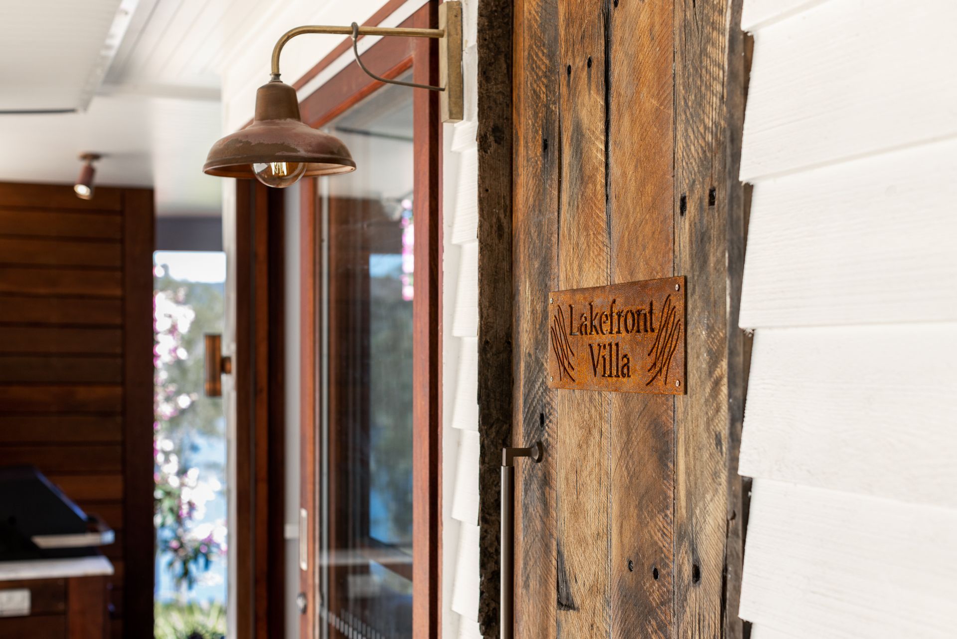 A wooden door with a sign on it and a light on it.