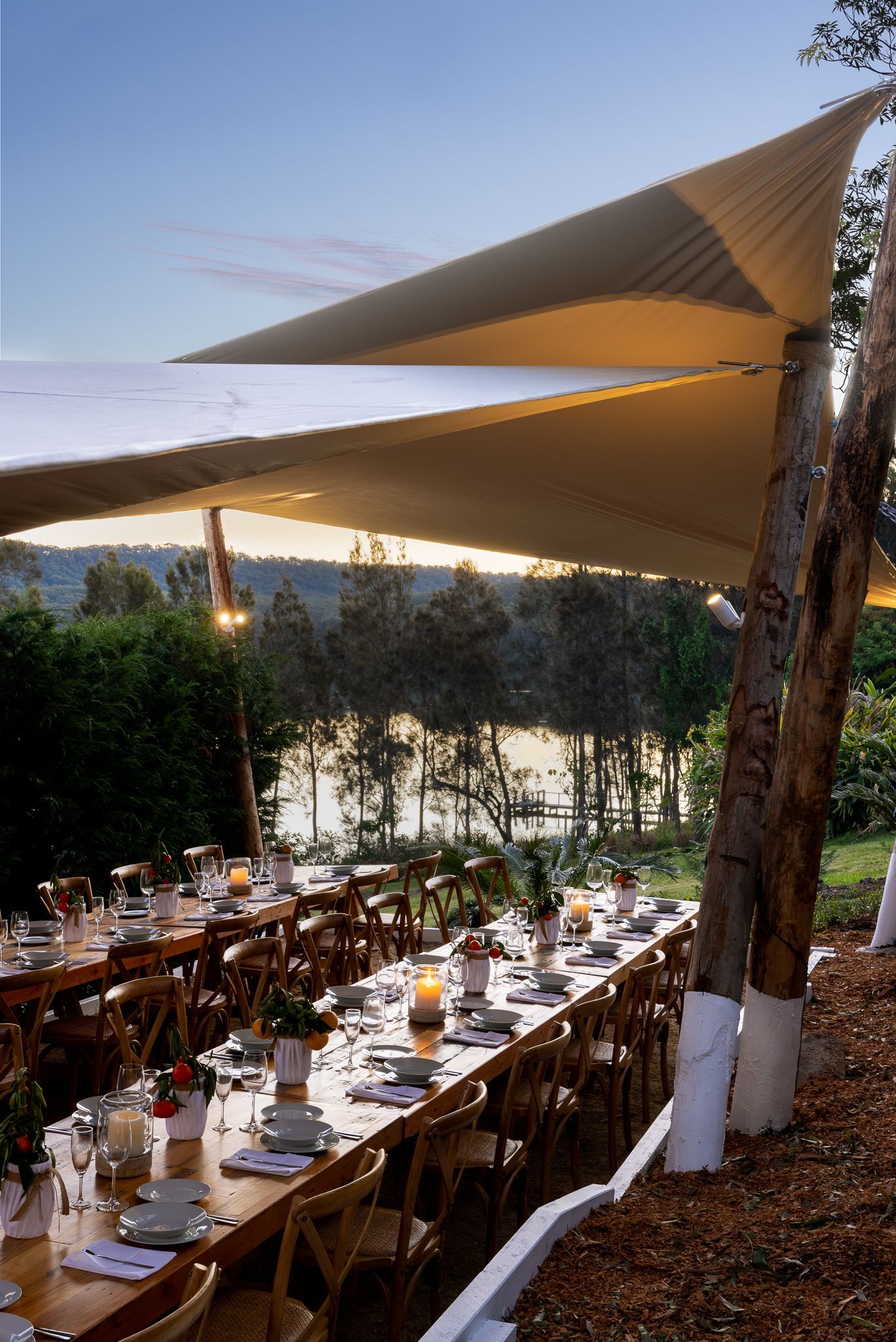 A long table with a view of a lake under an umbrella