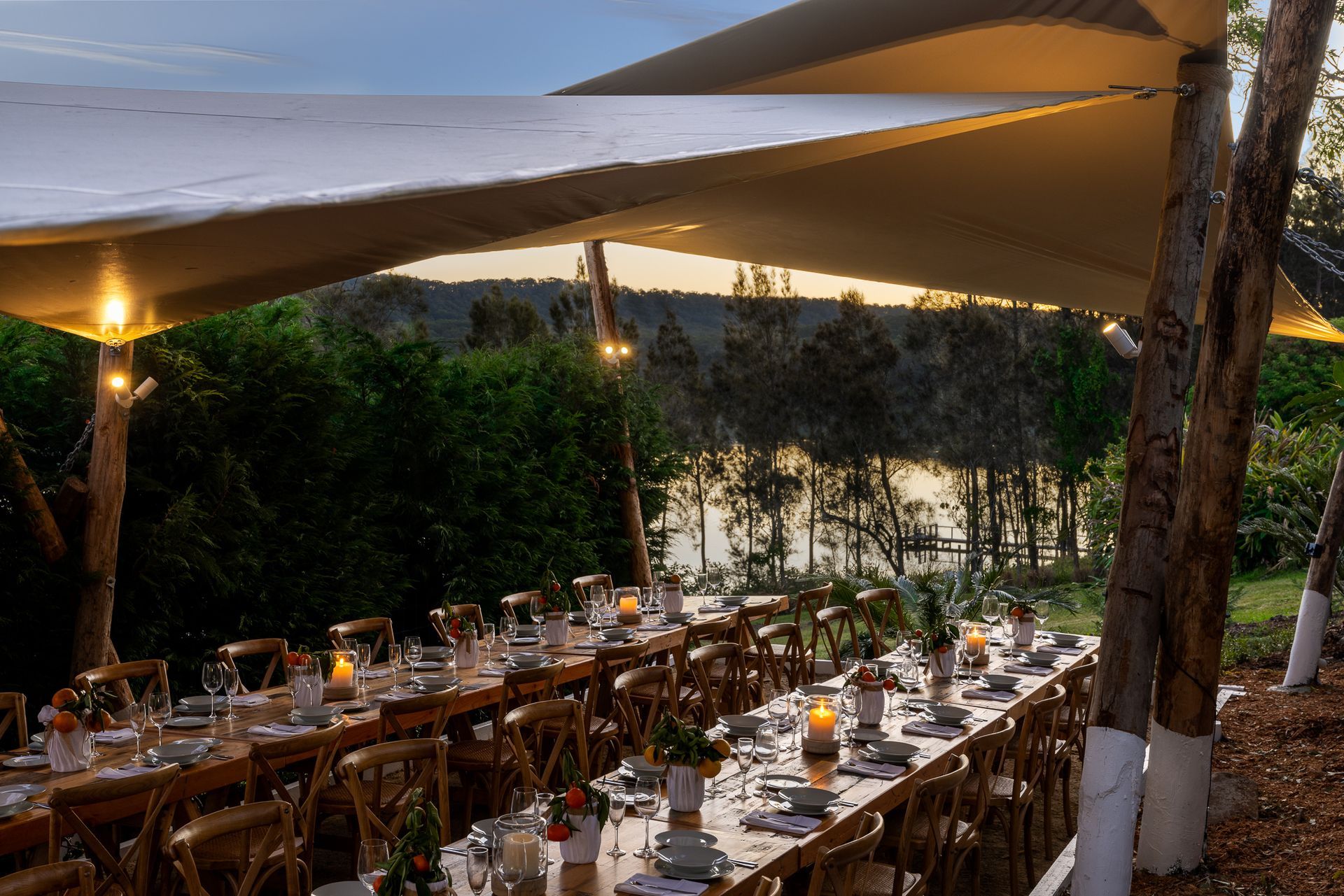 A long table with candles on it under a tent.