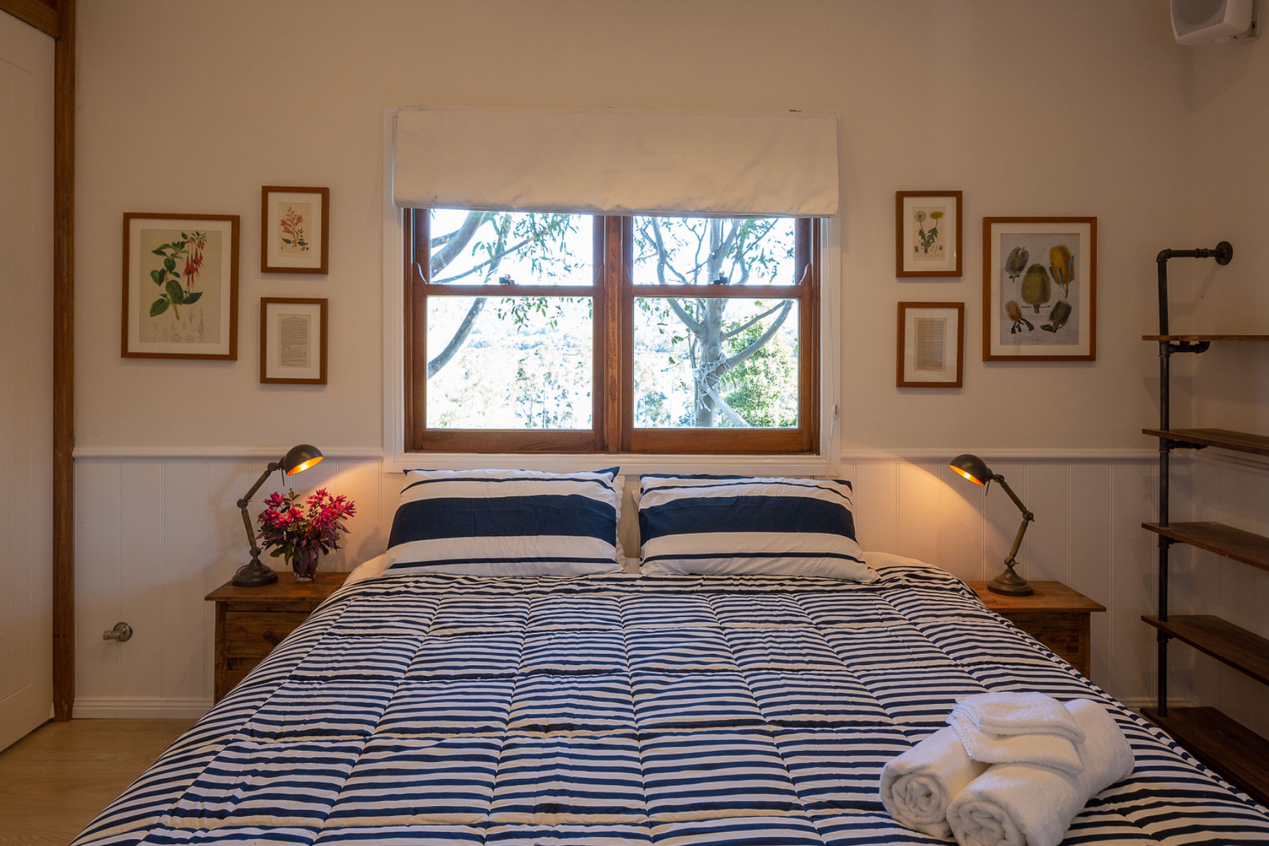 A bedroom with a large bed and two windows