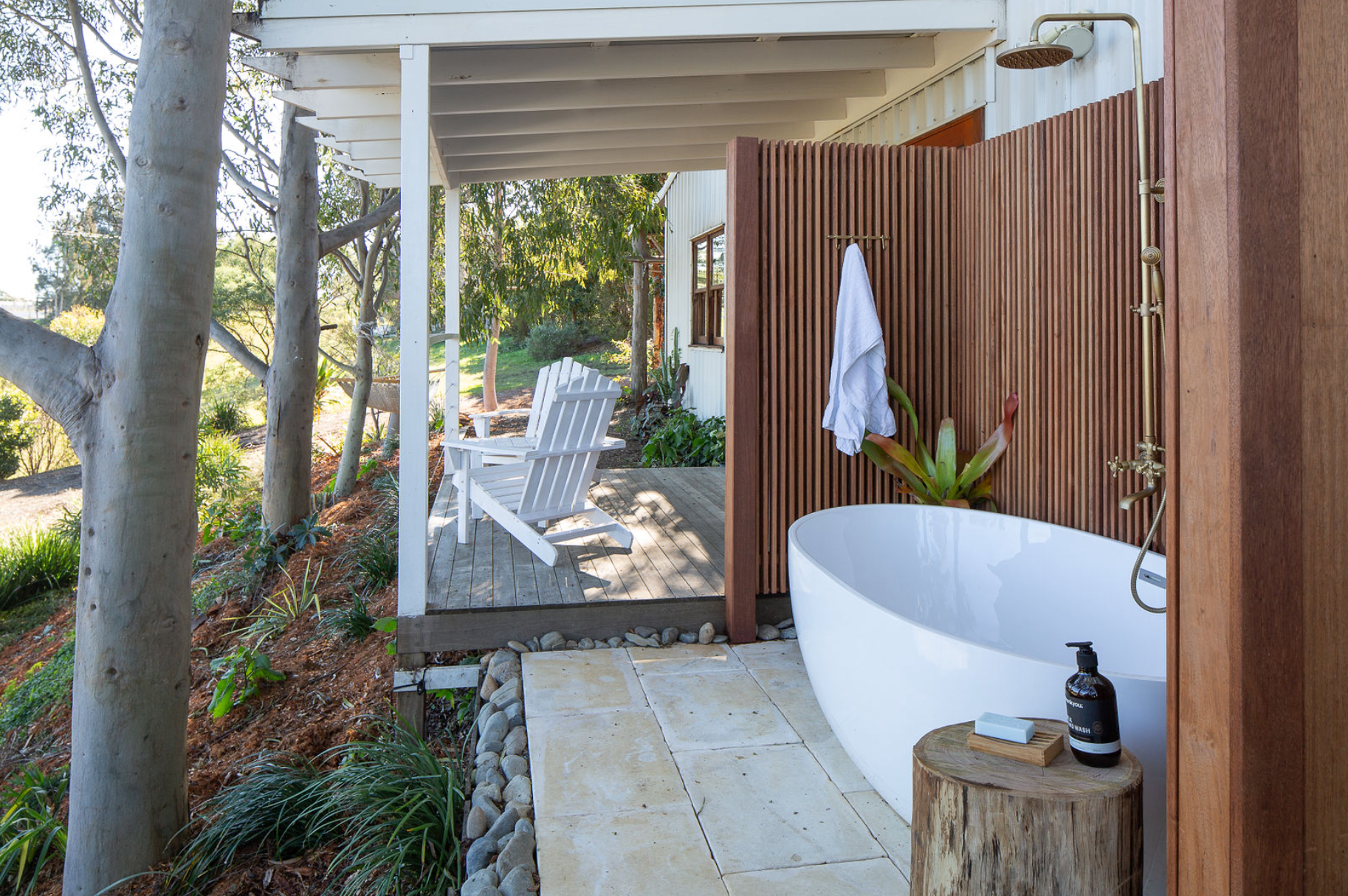 A bathroom with a bathtub and a shower outside.