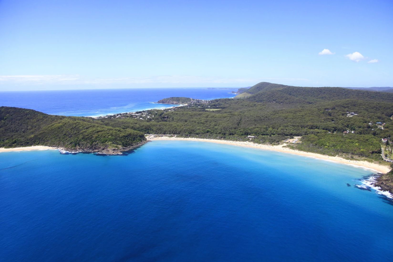 An aerial view of a large body of water with a beach in the distance.