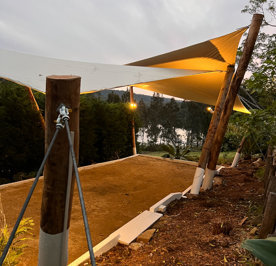 A large white tent is sitting on top of a dirt field