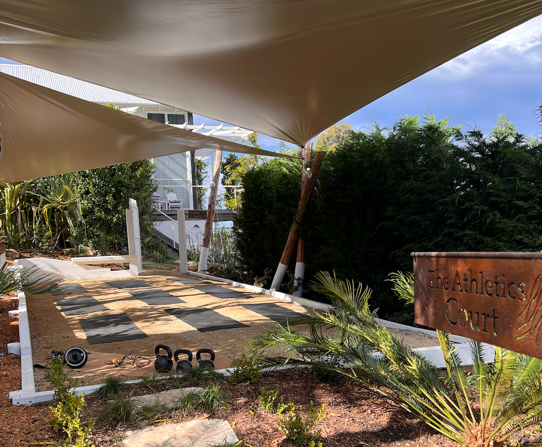 A large white tent is sitting in the middle of a garden.