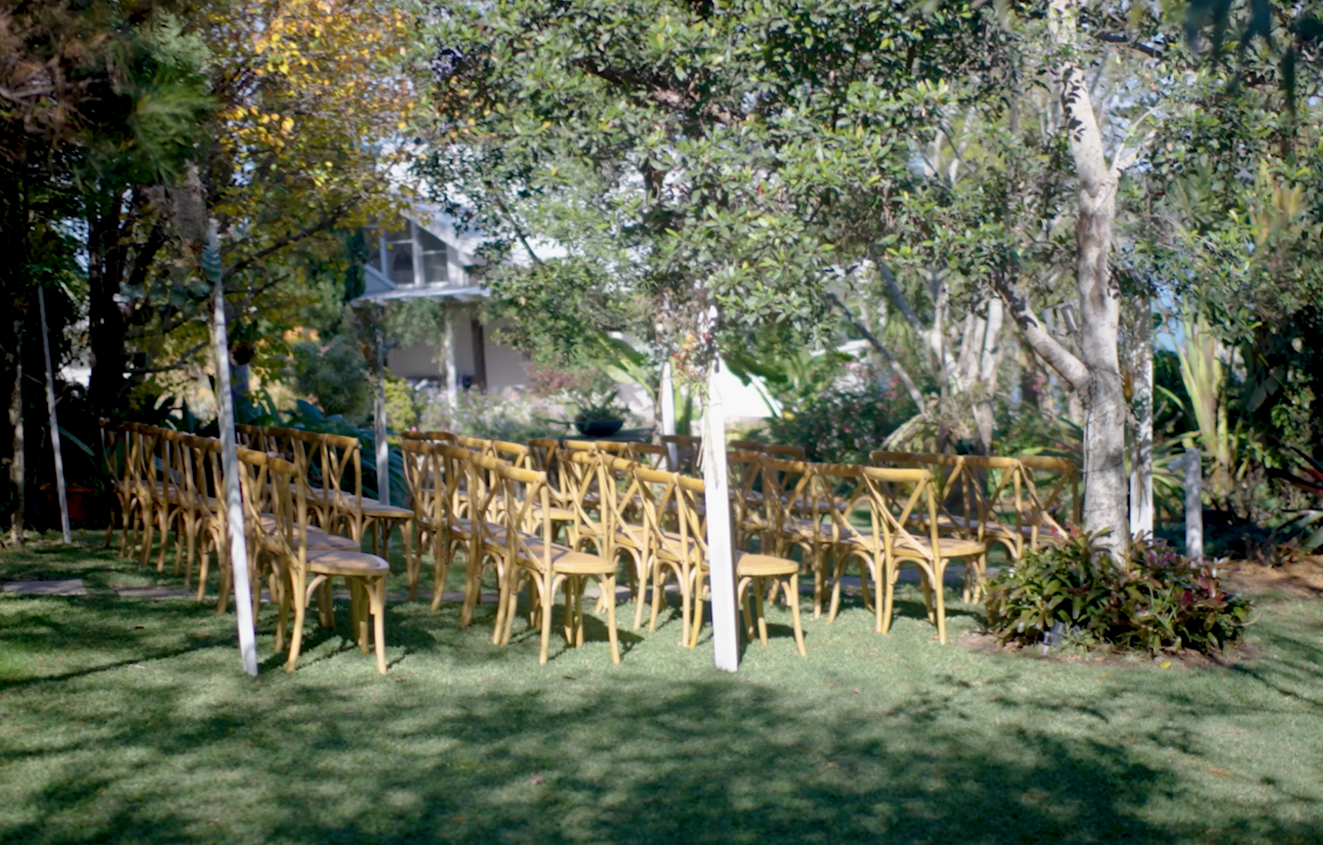 A row of wooden chairs are lined up in a row on a lush green field.