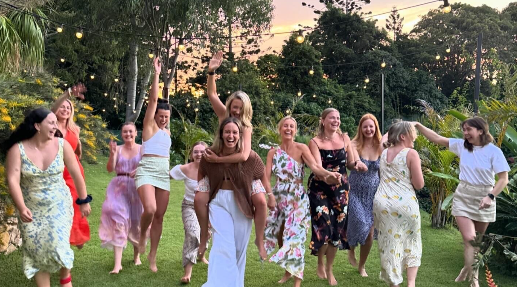 A group of women are standing in a circle in a field.