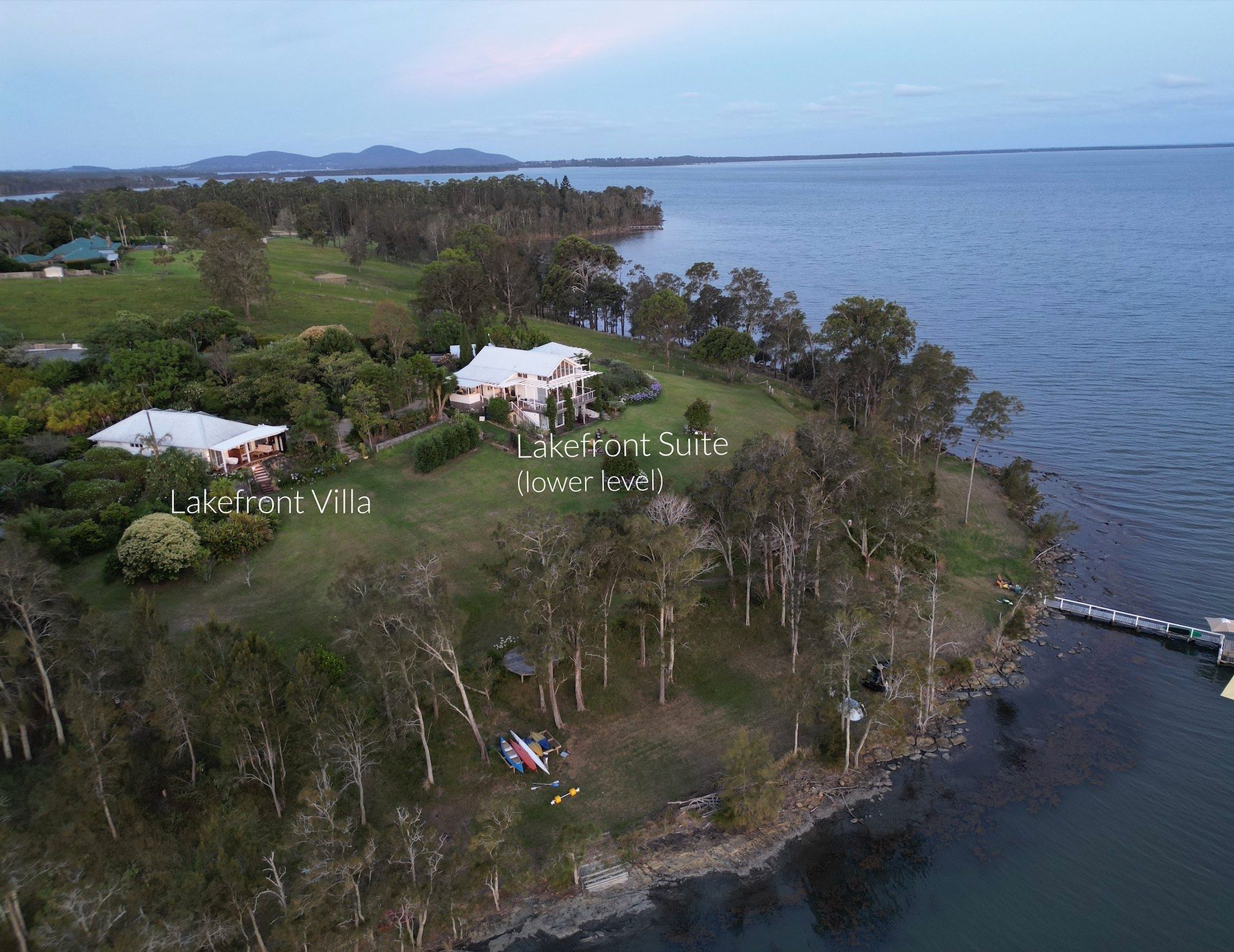 An aerial view of a house on a cliff overlooking a body of water.