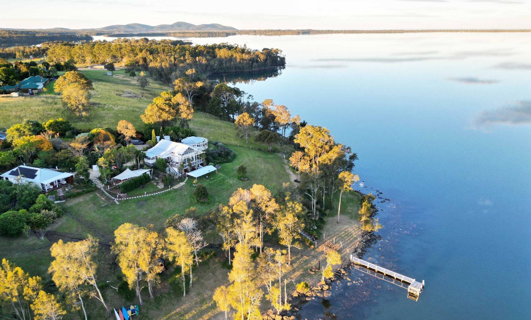 An aerial view of a large body of water surrounded by trees and houses.