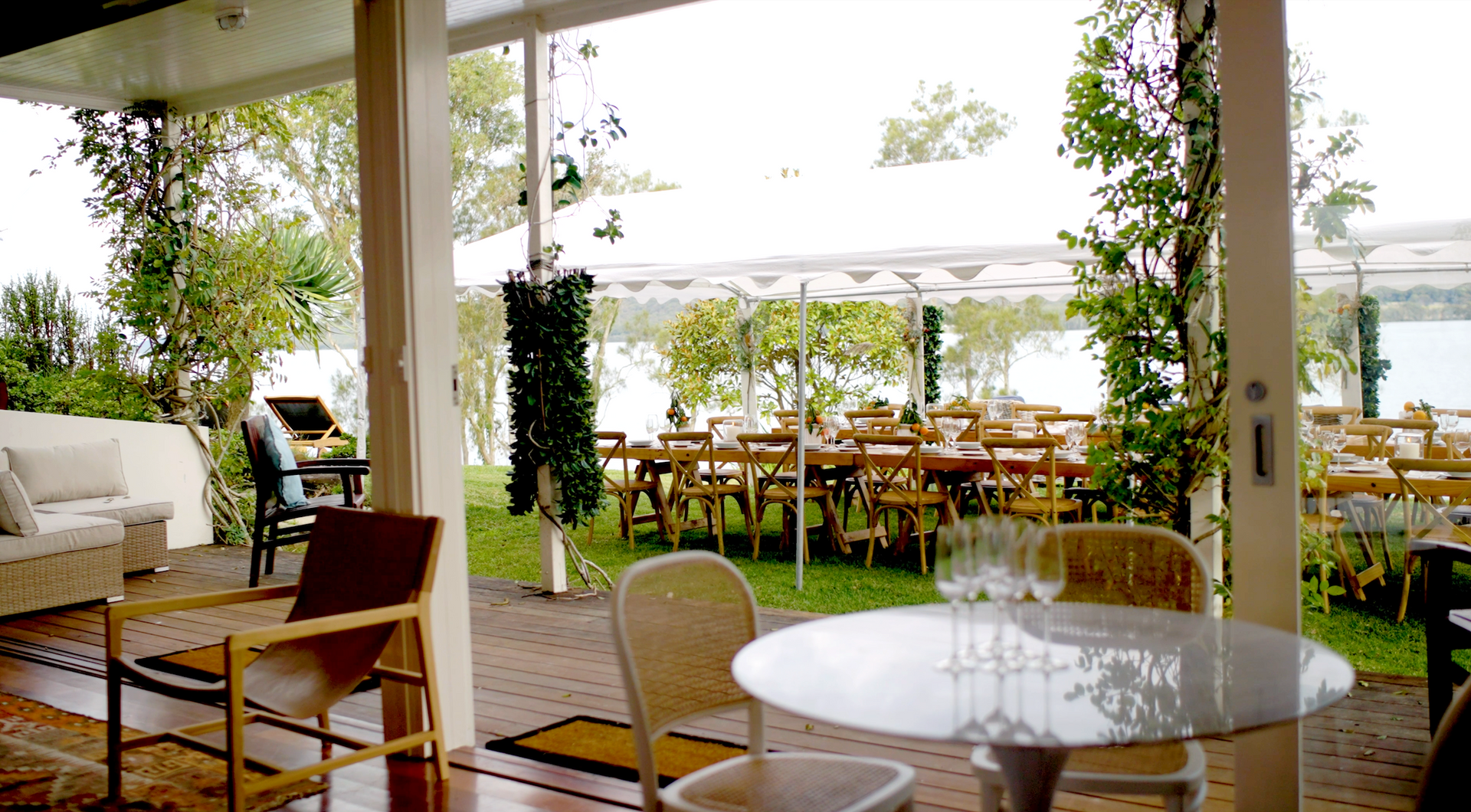 A patio with tables and chairs and a view of a lake