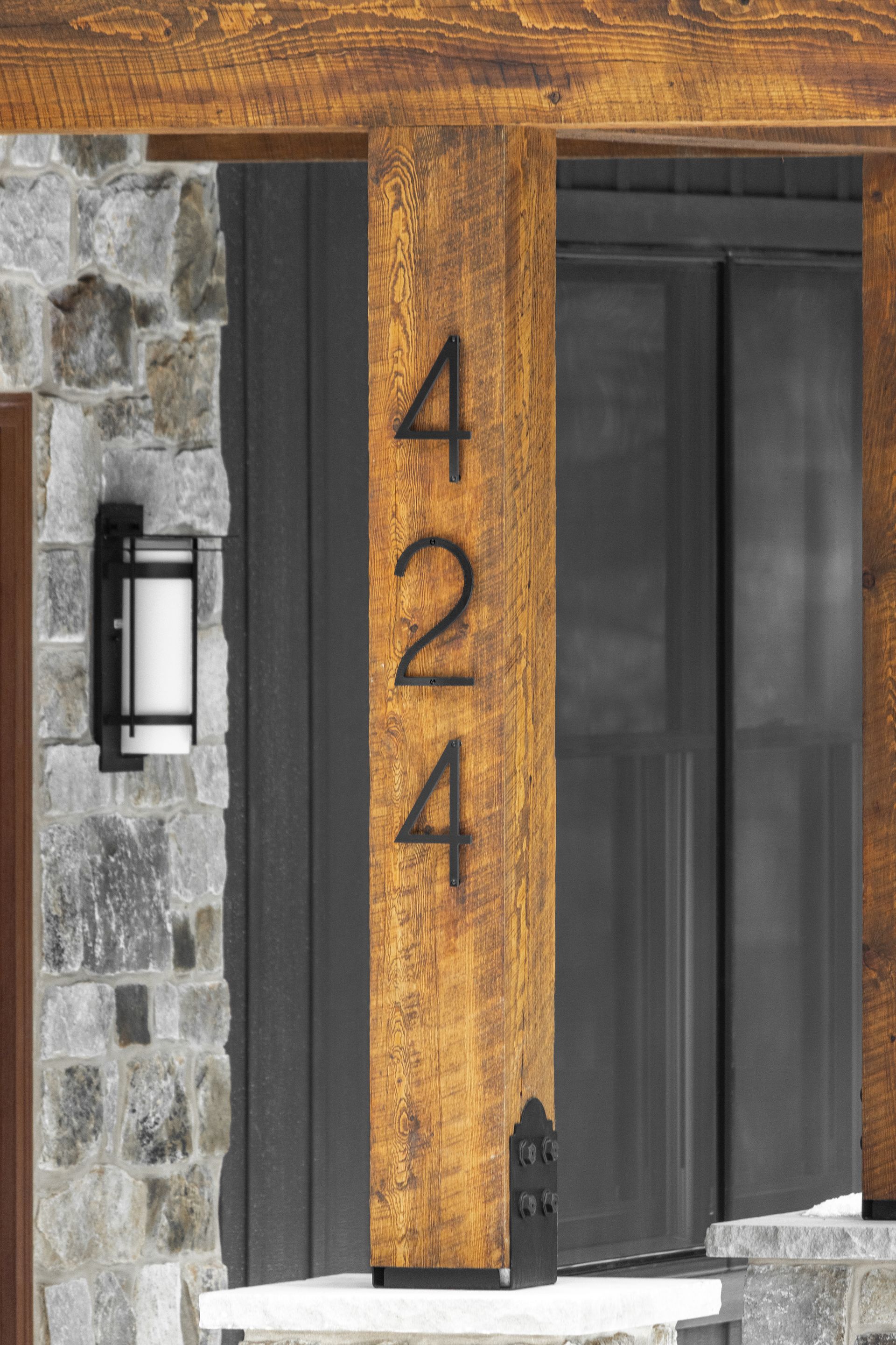 House entrance with orange wood trim, dark door, stone wall, and the number 424 displayed vertically