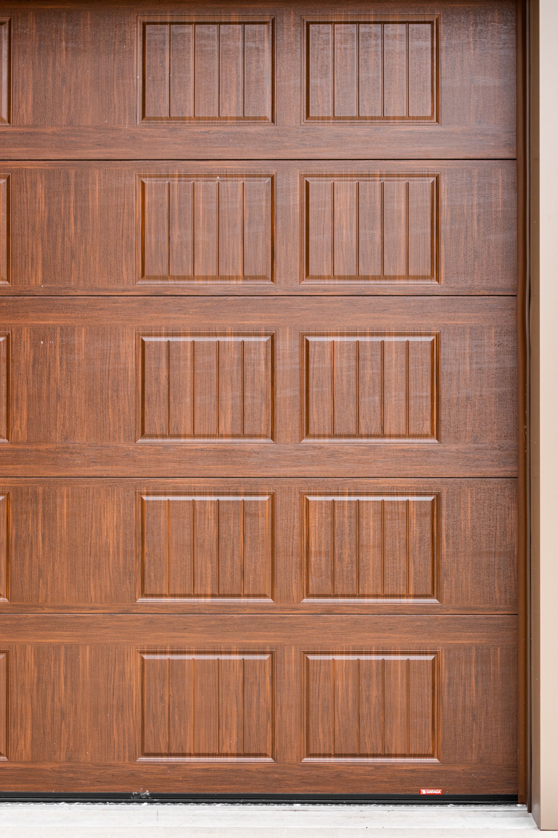 Brown paneled wooden garage door with a side window frame on the right