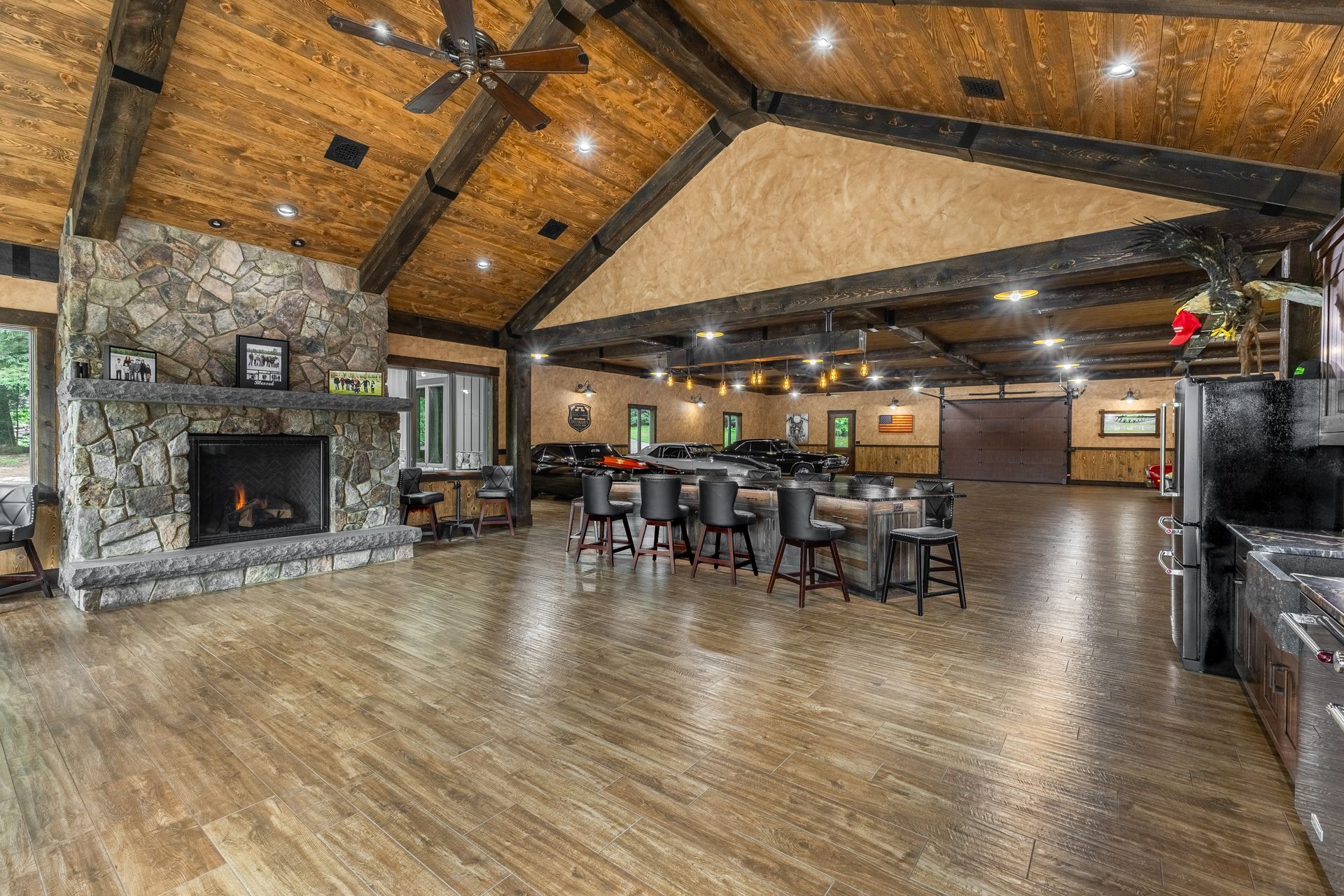 Spacious rustic lodge interior with stone fireplace, wood-beamed ceiling, and open dining area