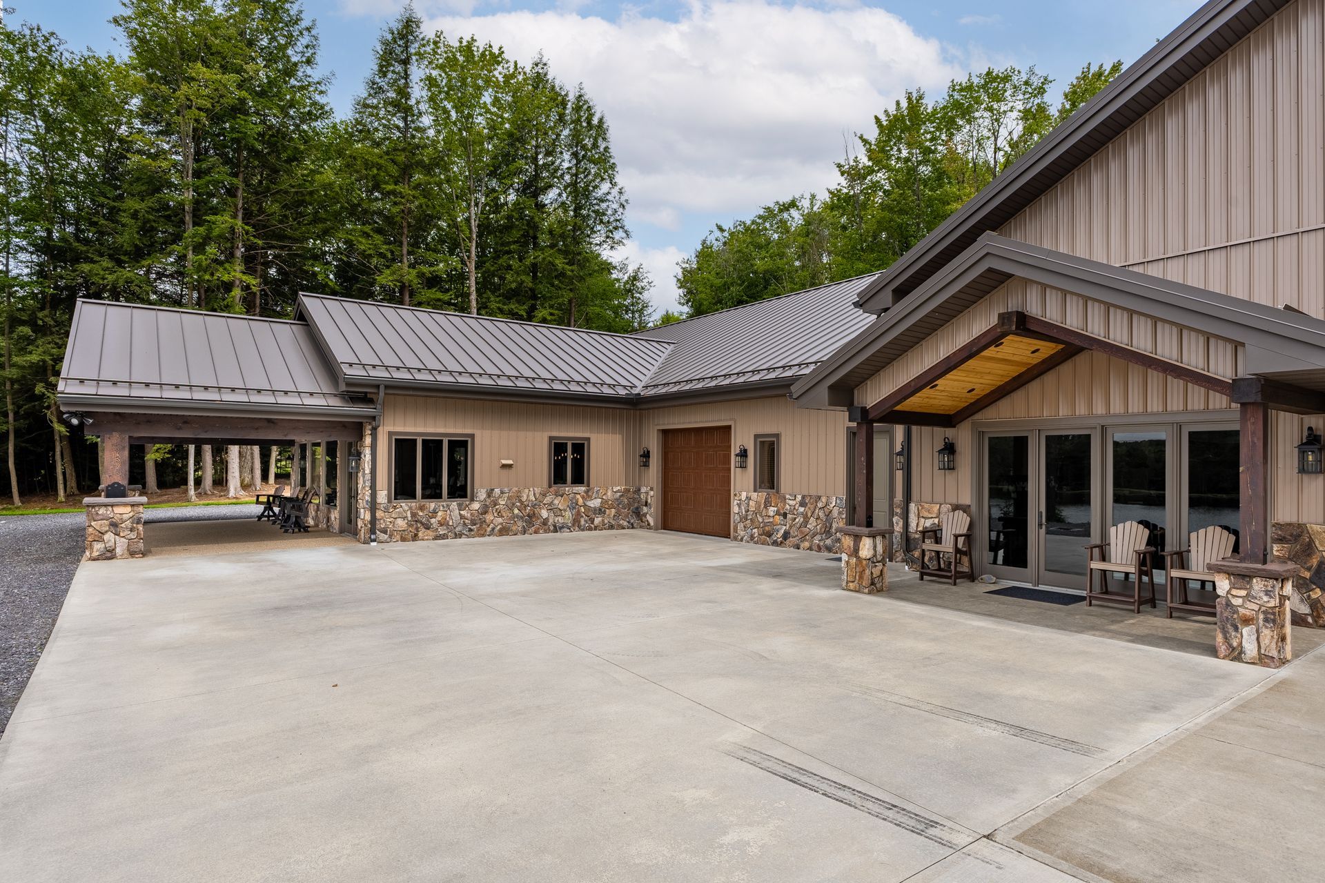 Modern building with stone accents and large windows surrounding a paved courtyard under trees
