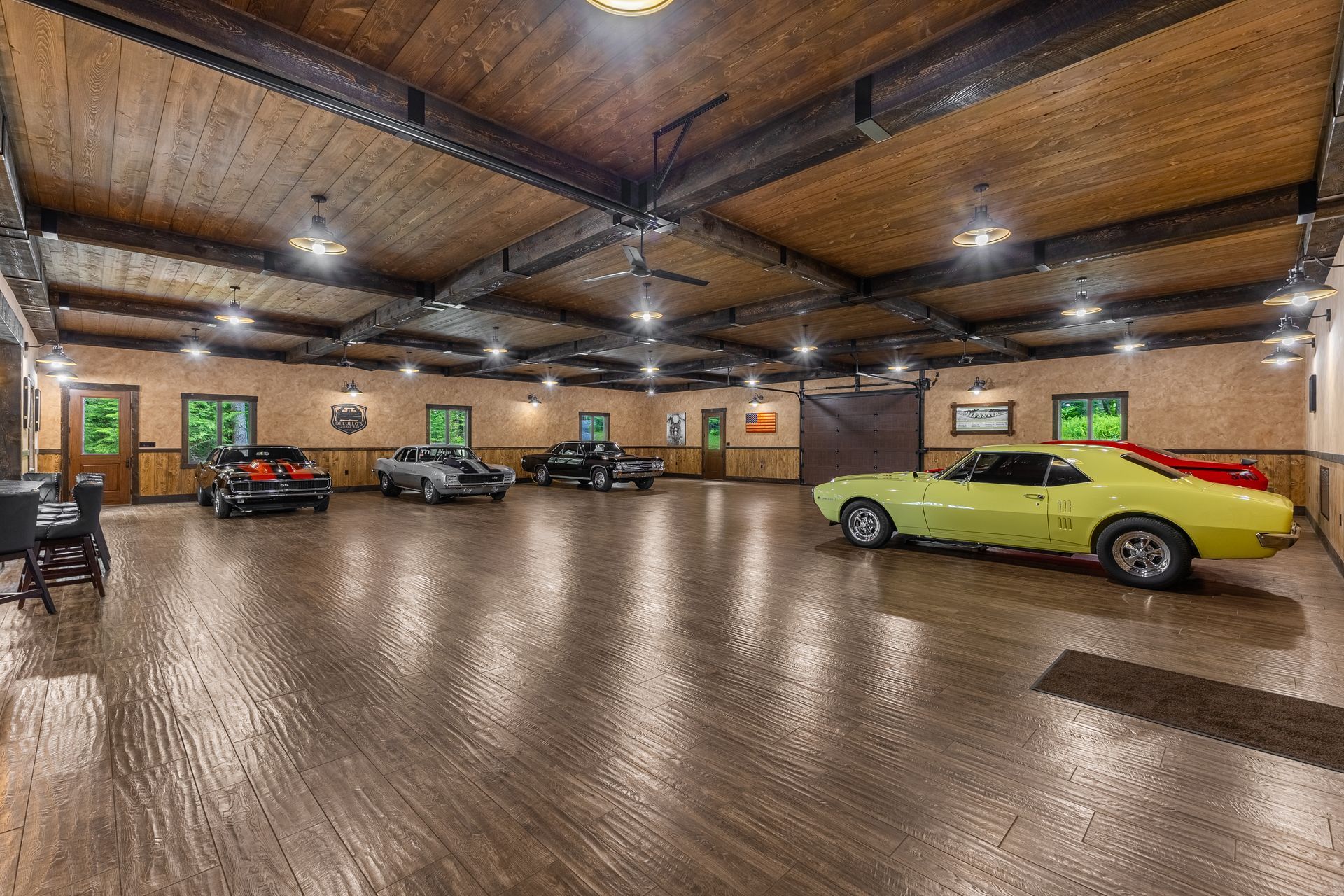 Spacious indoor garage with several parked cars and a glossy floor under warm ceiling lights