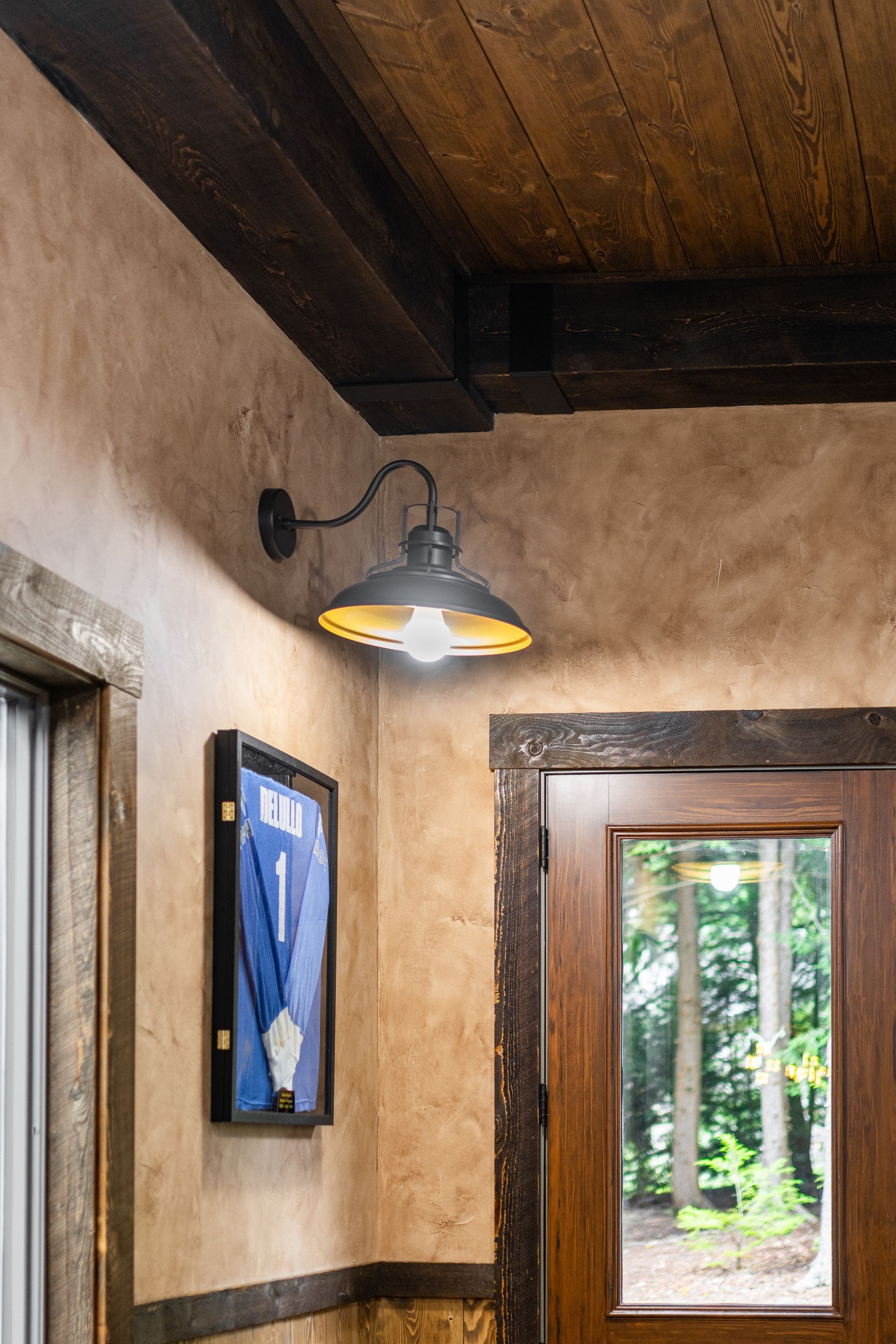 Rustic hallway with wall sconces, wood ceiling, and a view of greenery through a doorway