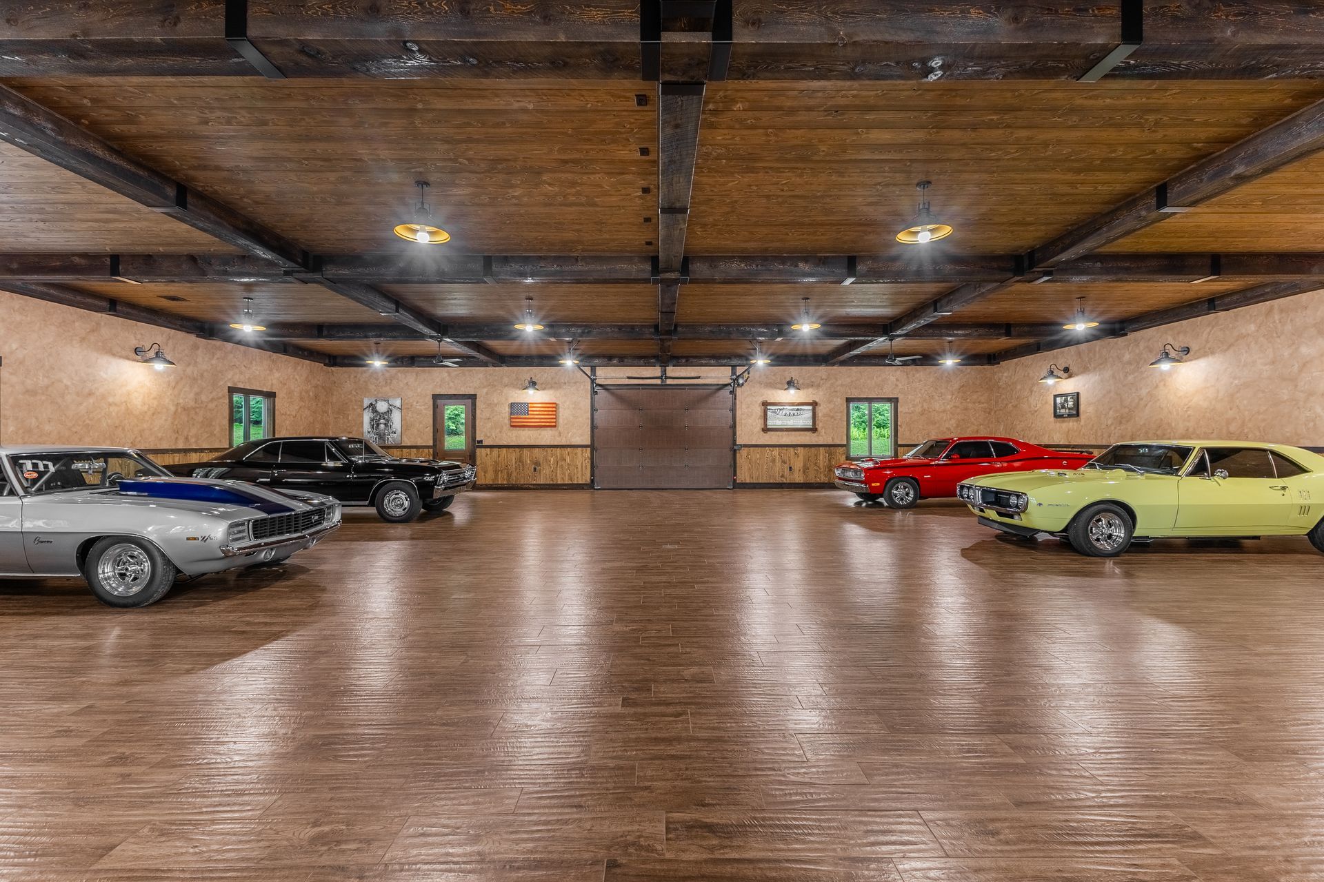 Indoor parking garage with several parked cars and a polished floor under wooden ceiling beams
