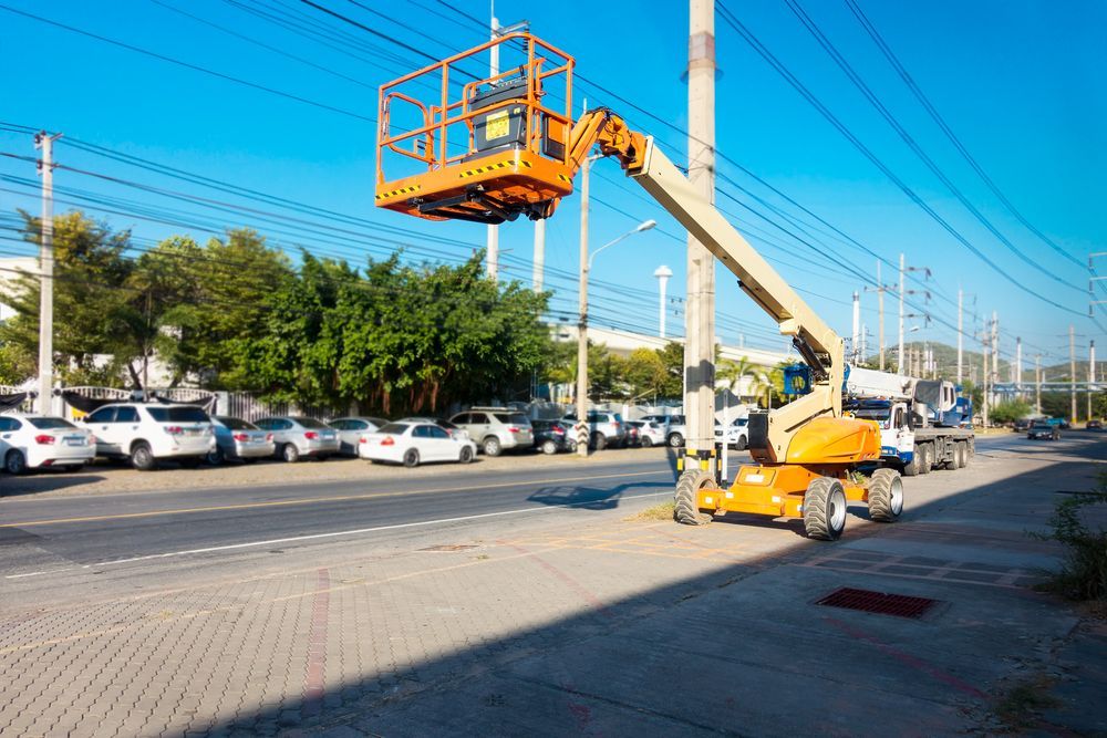 A Man Is Working on A Pole with A Crane in A Parking Lot — PEPS Machinery Services In Ipswich, QLD