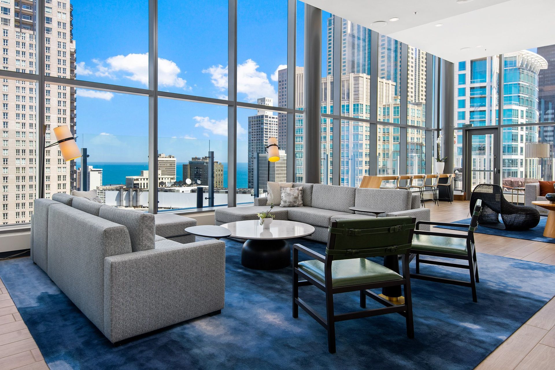 a living room with a view of the ocean and skyscrapers
