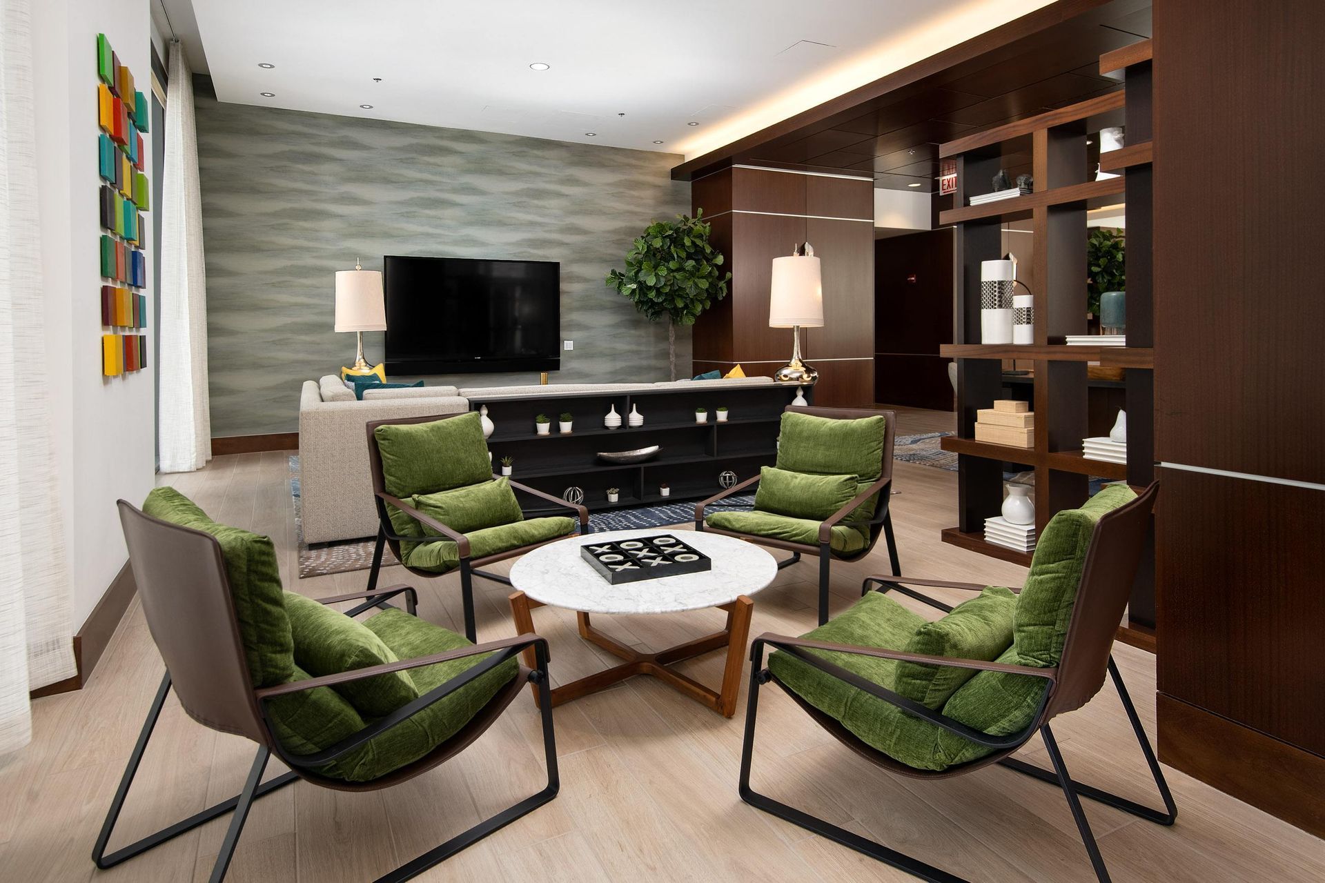 a living room with chairs and a table and a television