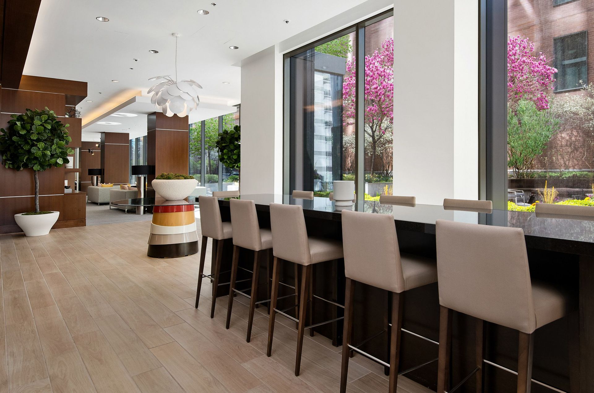 a long table with chairs in a room with large windows
