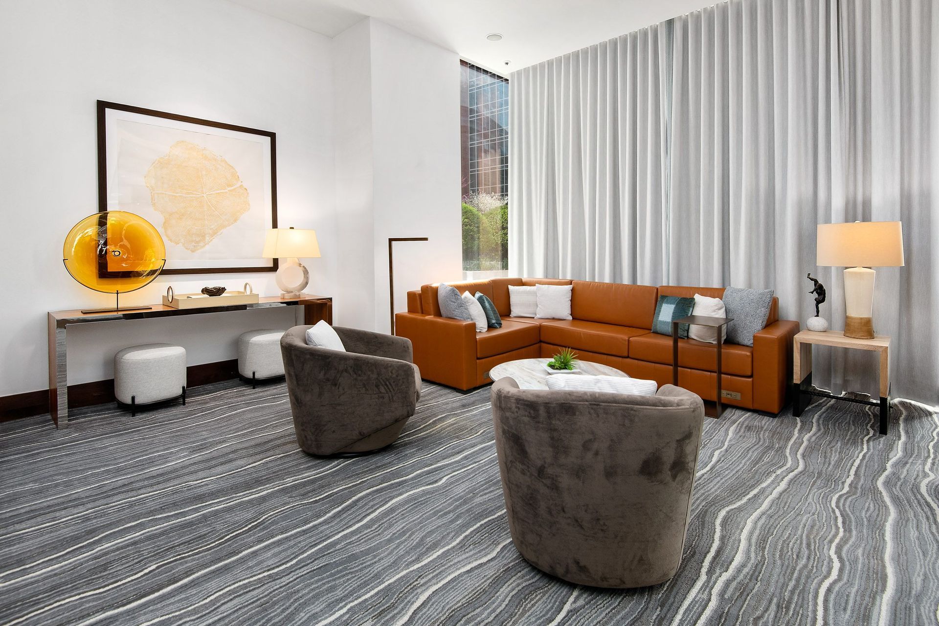 a living room with a couch and chairs and a desk