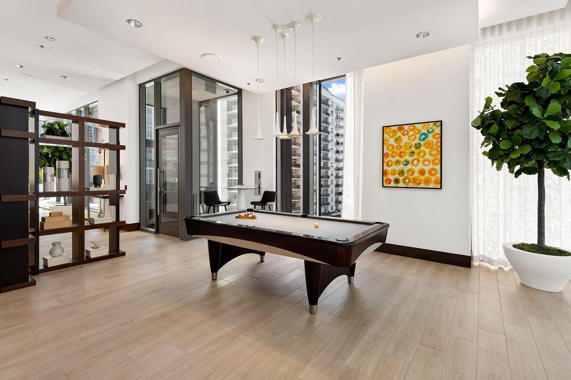 a game room with a pool table and a potted plant