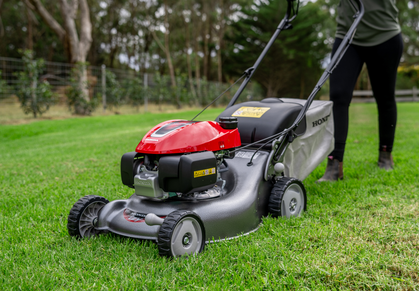 A Person Is Using A Lawn Mower On A Lush Green Lawn — Terrace Mowers in Raymond Terrace, NSW