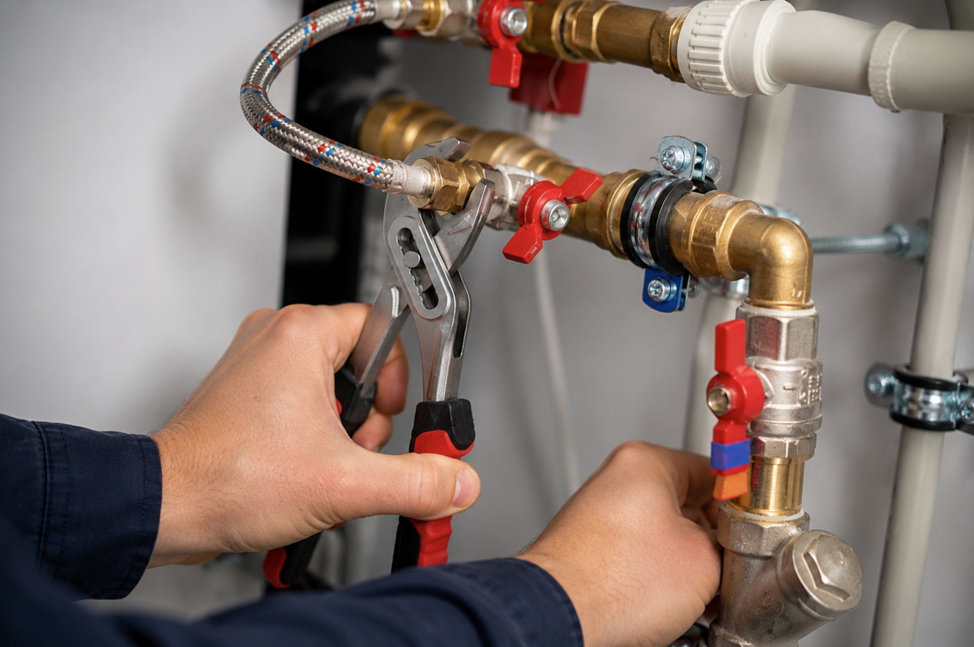 Licensed plumber repairing a pipe, representing quality plumbing companies service Licensed plumber repairing a pipe, representing quality plumbing companies service