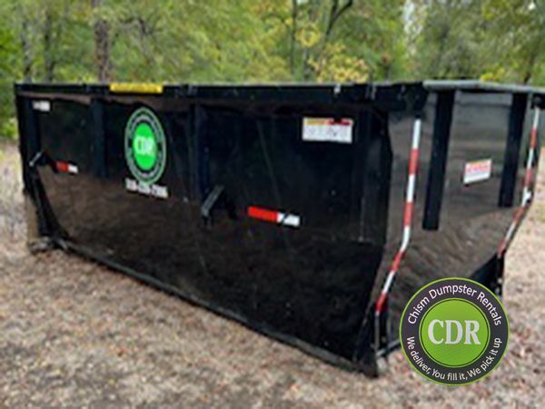 Large black construction dumpster with green CDR logos on a gravel lot.