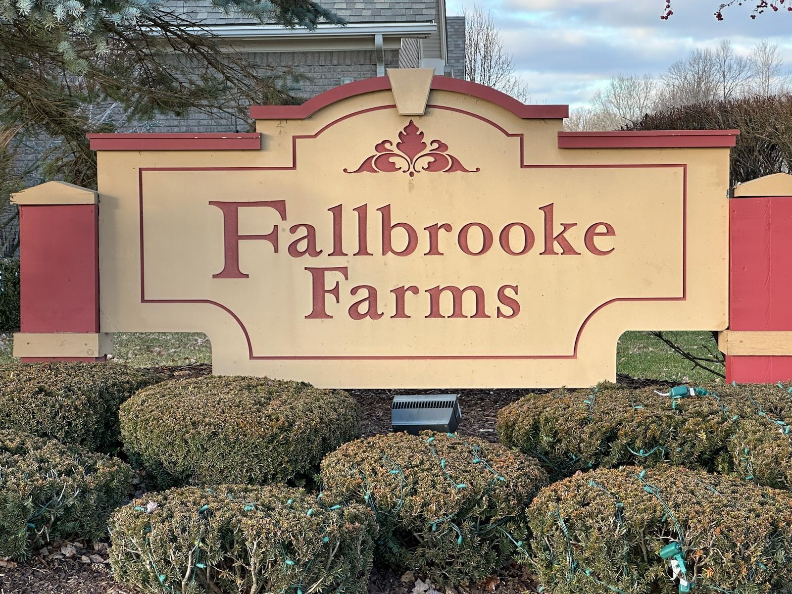 Fallbrooke Farms sign on a landscaped entrance, with pink and tan stonework.