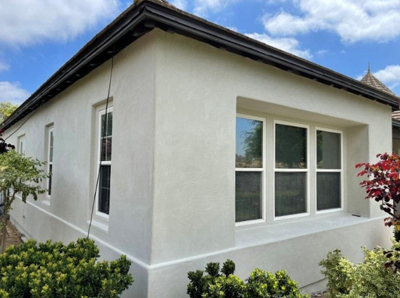 “Clean home exterior with light stucco walls, large windows, and a dark roof after a stucco service in Spring Valley, NV”
