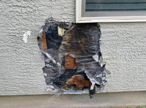 “Damaged stucco wall with a large exposed patch below a window before repair during a stucco service in Spring Valley, NV”
