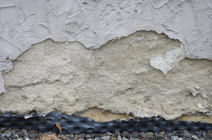 “Close-up of peeling and cracked stucco exposing worn layers underneath before remediation during a stucco service in Spring Valley, NV”