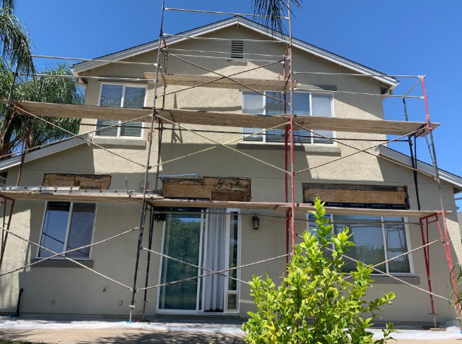 “Two-story home surrounded by scaffolding while exterior walls are being restored during a stucco service in Spring Valley, NV”