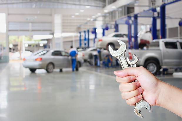 Hand holding wrenches inside garage | Freestate Auto & Truck Service