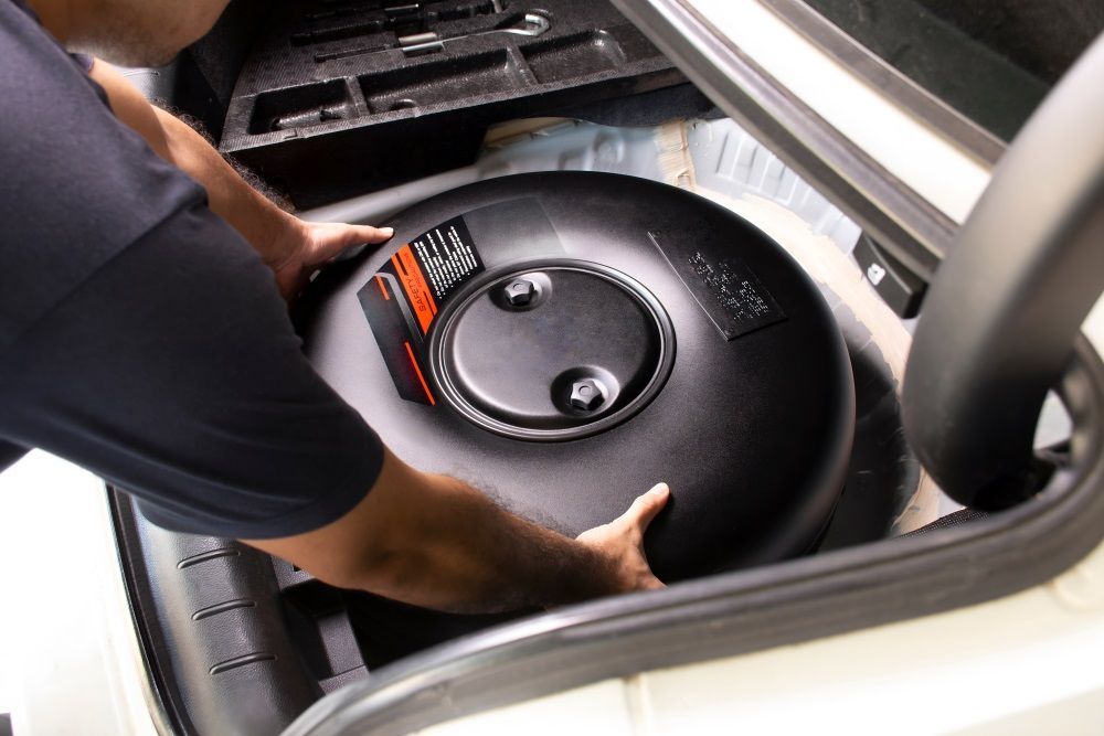 A Man Is Holding a LPG Cylinder in The Trunk of A Car — Raff's Advanced Automotive P/L in Fairy Meadow, NSW