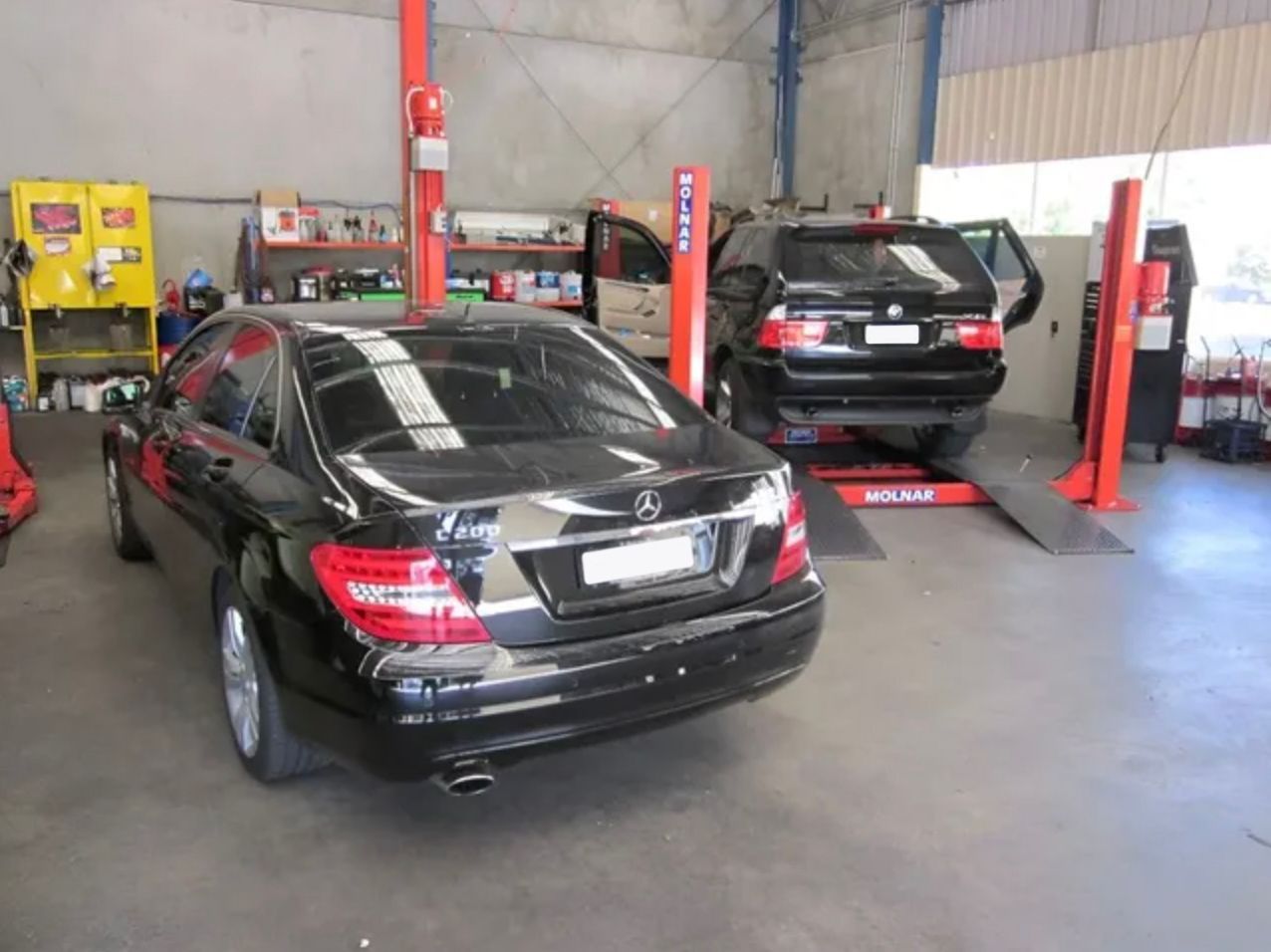 Two Cars Are Sitting on a Lift in a Garage — Raff's Advanced Automotive P/L in Fairy Meadow, NSW