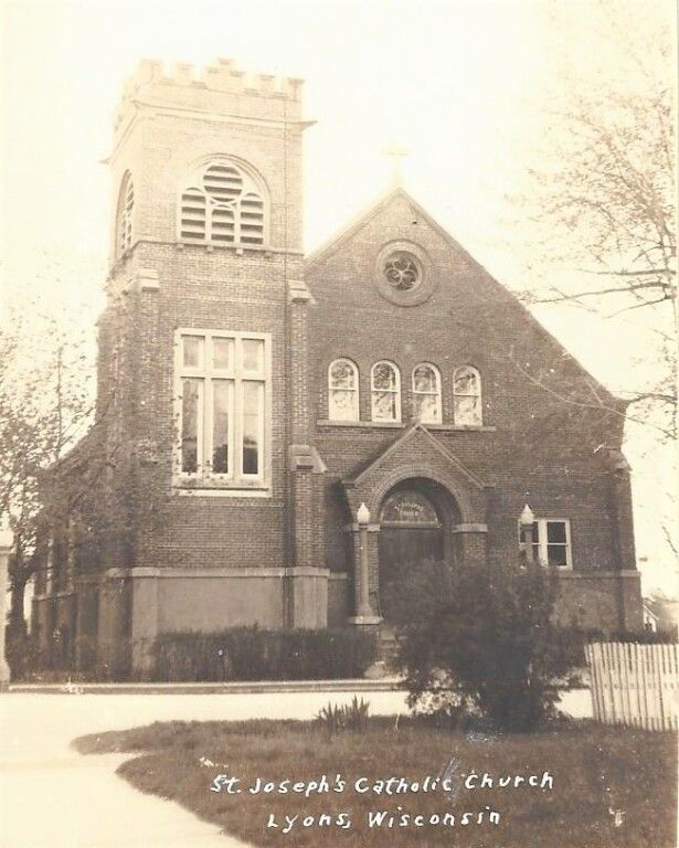 Historic brick church with tower and arched windows in snowy winter scene