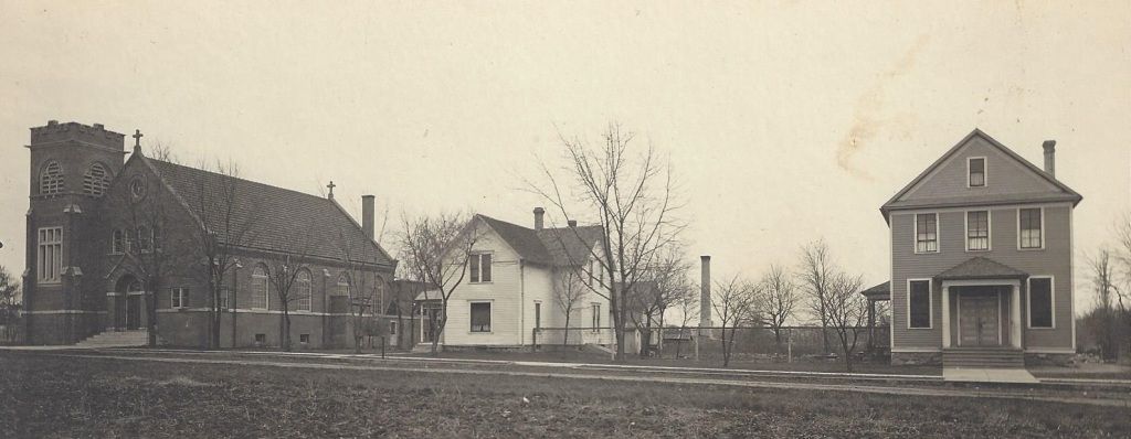 Sepia-toned view of a rural street with three old houses and leafless trees in winter