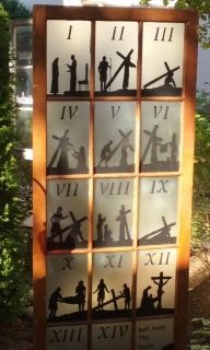 Wall-mounted panel of 12 numbered silhouette scenes arranged in a 3x4 grid, lit by warm light