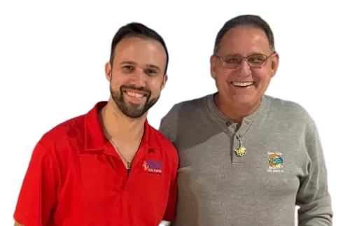 Brennan & Mike smiling, one in red polo shirt, the other in gray sweater, both looking at the camera.