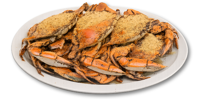 Plate of cooked blue crabs dusted with seasoning on a white platter