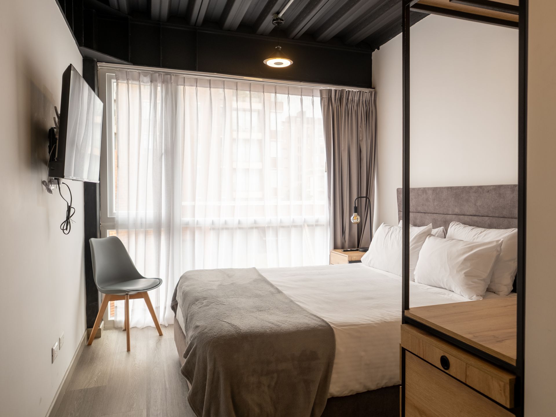Apartasuite with double bed, open closet, and desk at Nova Iorque.