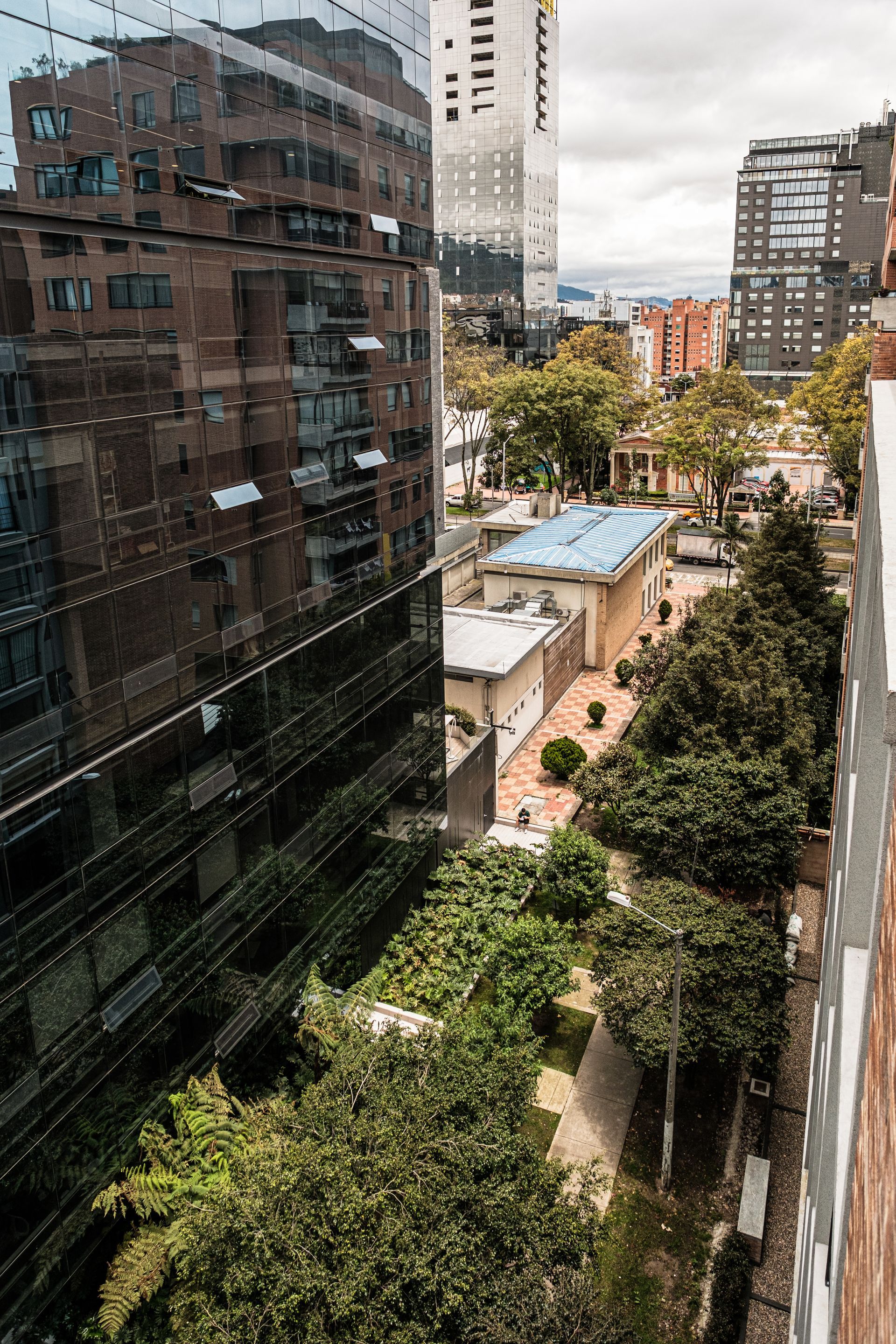 hotel ejecutivo Bogotá Nova Iorque con vista urbana, edificios cercanos, árboles y montañas al fondo